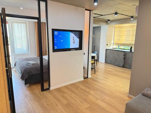 a bedroom with a bed and a flat screen tv at Nice Apartment in the Center, with Balcony in Crăsnăşeni