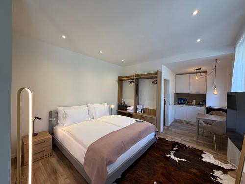 a bedroom with a large bed and a kitchen at LA VILLA - by Hotel Remorino in Locarno