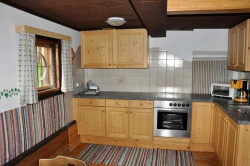 uma cozinha com armários de madeira e um fogão em Almhütte Ödenhübl em Katschwald