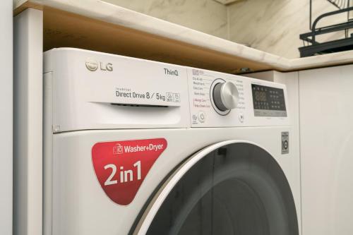 a white washing machine with a red sticker on it at The Whitehouse M6, Junction 10 With Parking in Walsall