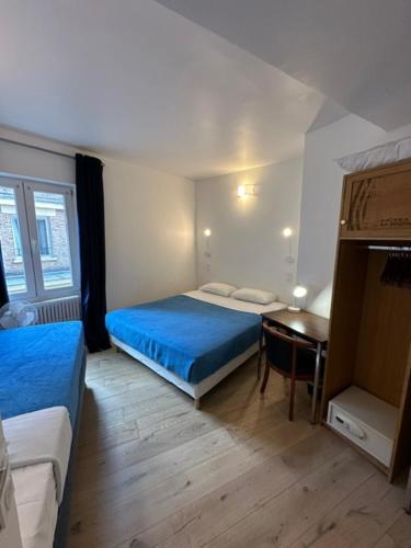 - une chambre avec 2 lits, un bureau et une table dans l'établissement Hotel La Louisiane, à Paris