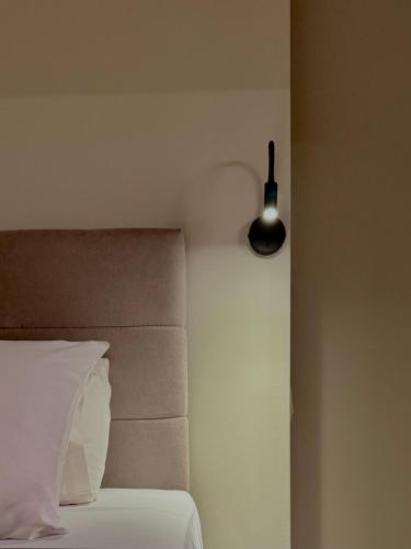 a bedroom with a bed with a light on the wall at Noma Suites Tolo in Tolo