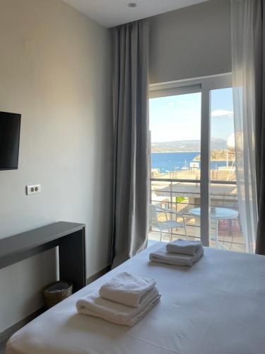 a bedroom with a bed with a view of the ocean at Noma Suites Tolo in Tolo