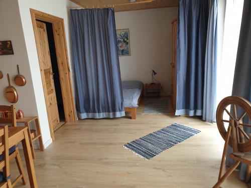 a living room with a blue curtain and a bedroom at Gegenüber der Mühle in Kall