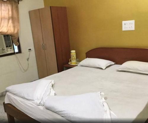 a bedroom with two beds with white sheets and a telephone at Hotel Parth in Nagpur