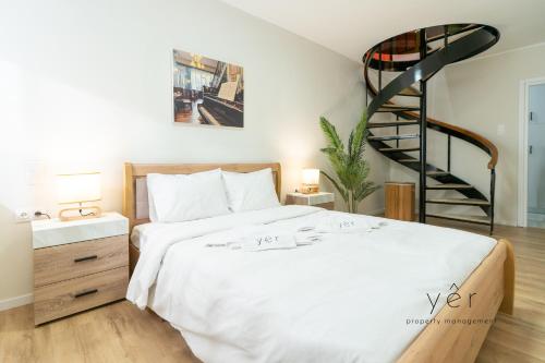 a bedroom with a bed and a spiral staircase at Duplex in Piraeus' Best Street 2Bath w-FreeParking in Piraeus