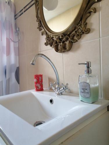 a bathroom sink with a soap bottle and a mirror at Bluefullstop-Μπλε Τελεία in Artemida