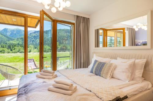 a bedroom with a bed with a large window at Apartamenty Enklawa pod Giewontem by Apart Concept Podhale in Kościelisko