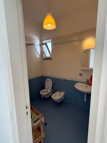 a bathroom with a toilet and two sinks and a window at Fantasy House 2.0 in Forio d'Ischia