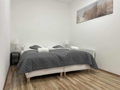 a white bedroom with a bed with a gray blanket at MIRA apartments in Prague