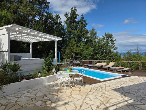 a patio with a table and chairs next to a swimming pool at Apartments Chiara mit Meerblick und Pool und Jacuzzi in Lovran