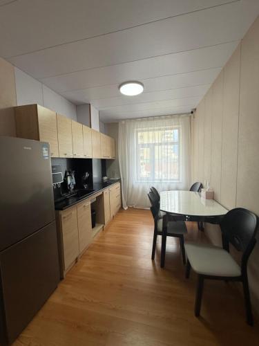 a kitchen with a table and chairs and a refrigerator at Rom Etuga guesthouse in Ulaanbaatar