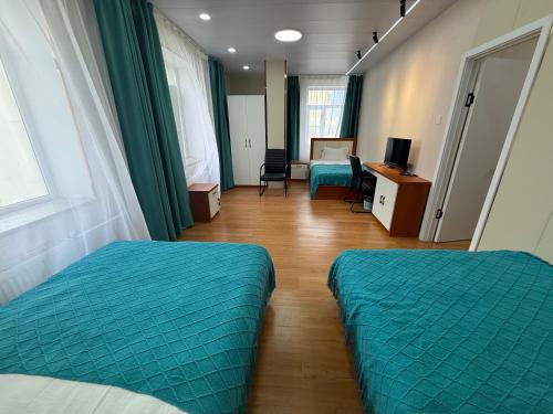 a room with two beds and a bedroom with a desk at Rom Etuga guesthouse in Ulaanbaatar