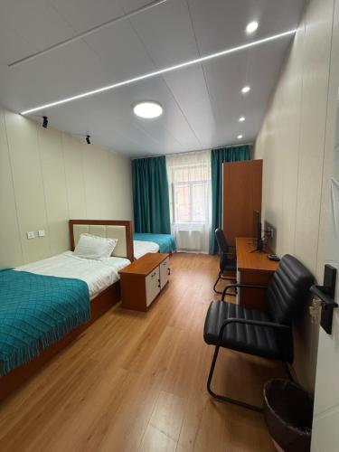 a bedroom with a bed and a desk and a chair at Rom Etuga guesthouse in Ulaanbaatar