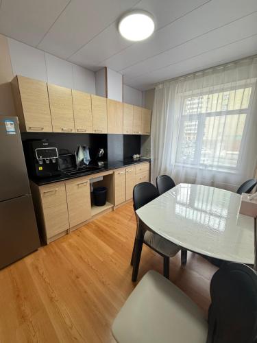 a kitchen with a table and chairs in a room at Rom Etuga guesthouse in Ulaanbaatar