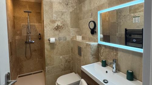a bathroom with a shower and a toilet and a sink at Hôtel La Pinède in Soulac-sur-Mer