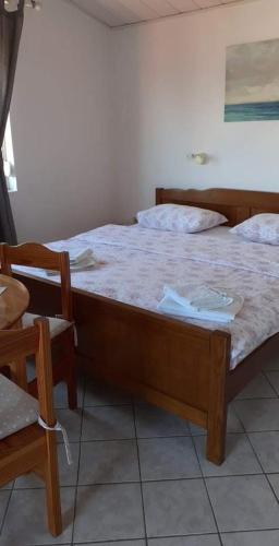 a bedroom with a large bed and a chair at Guesthouse Tariba in Supetarska Draga