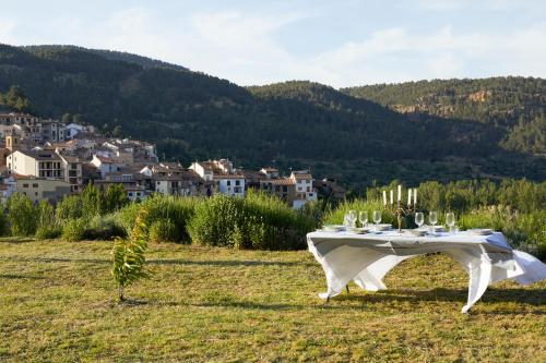 a table in a field with a view of a town at La Casa de Los Moyas in Olba