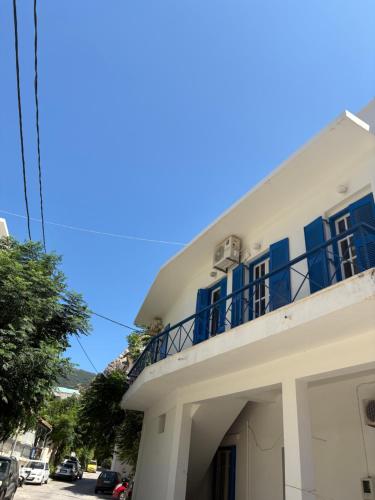 a white house with blue doors and a balcony at Violeta in Agios Kirykos