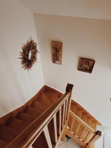a wooden staircase with a wreath on the wall at Le gîte de Marceau 