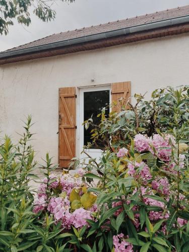 a house with pink flowers in front of it at Le gîte de Marceau 