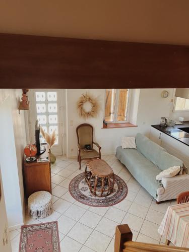 a living room with a blue couch and a table at Le gîte de Marceau 
