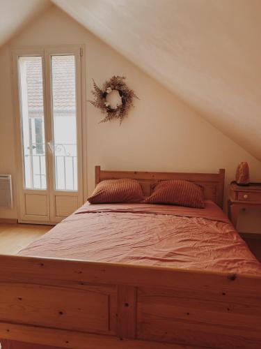 a bedroom with a bed with areath on the wall at Le gîte de Marceau 
