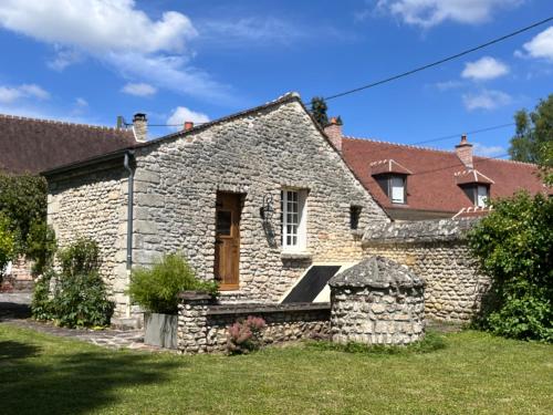 a stone house with a bench in the yard at La petite maison de Boisrival in Bury