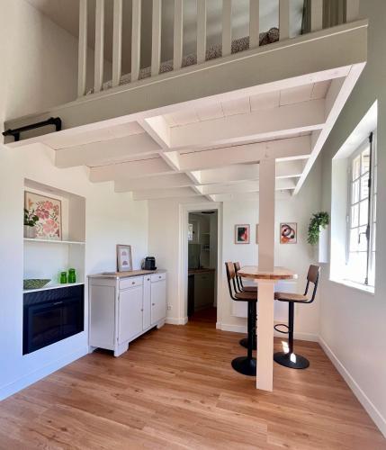 a dining room with a table and aamed ceilings at La petite maison de Boisrival in Bury