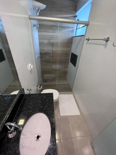 a bathroom with a toilet and a glass shower at Pousada Capitólio in Capitólio