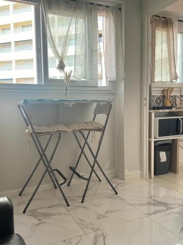 une table et une chaise dans une pièce avec une fenêtre dans l'établissement Le studio des catalans, à Marseille