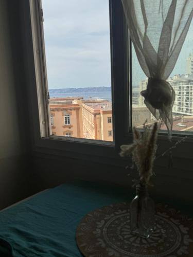 un vase sur une table devant une fenêtre dans l'établissement Le studio des catalans, à Marseille