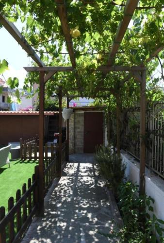 a garden with a wooden pergola and a yard at Monti' B&B Agropoli Lungomare in Agropoli
