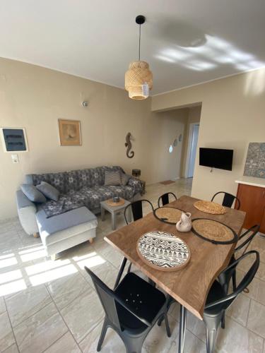 a living room with a table and a couch at Violeta in Agios Kirykos