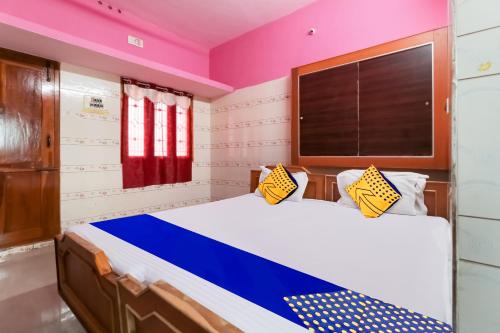 a bedroom with a bed with a blue and white comforter at SPOT ON Apple Tree Cottage in Palani