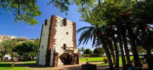 a brick tower in a park with palm trees at Miramar 4 - San Sebastin de La Gomera in San Sebastián de la Gomera