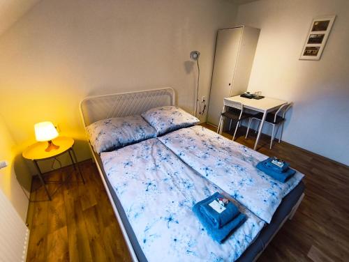 a bedroom with a bed with blue sheets and a table at Ubytování U Tajčů in Dolní Beřkovice