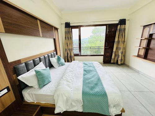 a bedroom with a large bed with a window at The Ananta Palampur in Pālampur