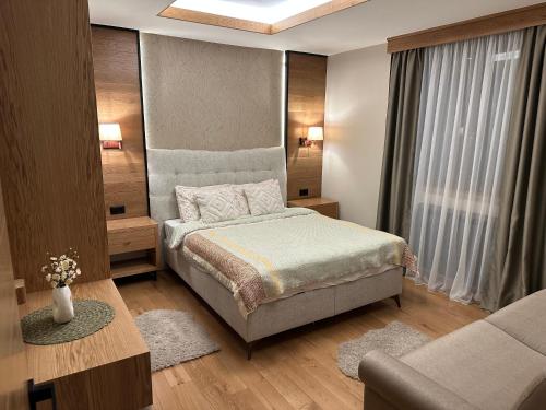 a small bedroom with a bed and a couch at Apartment MonteBreza Spa in Kolašin