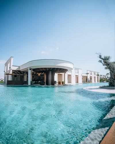 プリシュティナにあるVenus Hotelの建物の前の青い水のプール