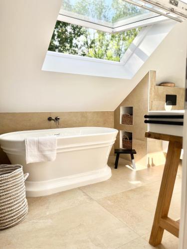 a bathroom with a white bath tub and a piano at TauberChalet I Privates Boutique-Ferienhaus mit Whirlpool, Sauna, Garten, Naturmagie & ZellBoost in Rothenburg ob der Tauber