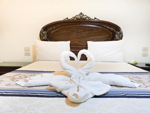 two towel swans making a heart on a bed at Afnan Cairo Airport in Cairo