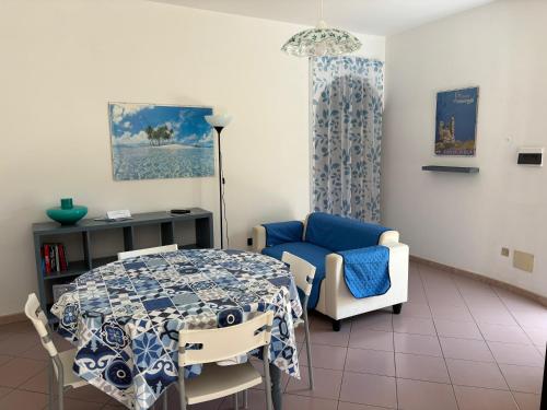 a living room with a table and a blue chair at Casa Pélagos a 50mt dal mare in Nicotera Marina