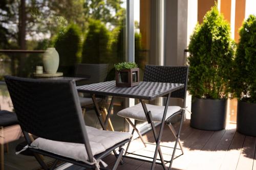 a table and chairs on a porch with plants at SkyGarden Studio - Private Terrace and View in Quiet Jūrmala in Jūrmala
