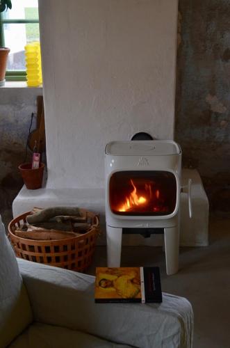 a stove with a fire in it next to a couch at Stylish seaside barn in Borrby