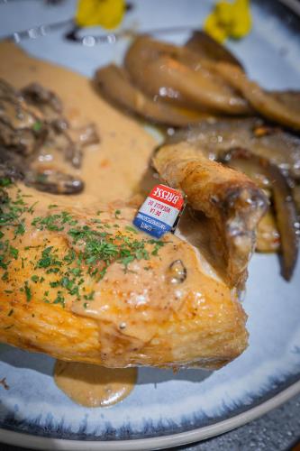 a plate of food with meat and mushrooms on it at Logis Hôtel Vuillot in Cuiseaux