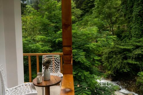 a balcony with a table and a view of a river at Tarzan Stays Jibhi in Shoja