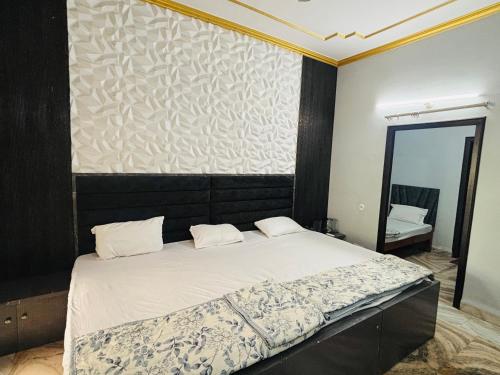 a bedroom with a large bed with a mirror at Hotel Radha Madhavam Luxurious Boutique Stay in Mathura