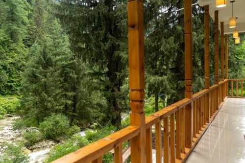 a wooden walkway with trees in the background at Tarzan Stays Jibhi in Shoja