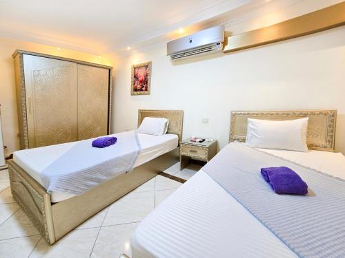 a hotel room with two beds with purple towels at Afnan Cairo Airport in Cairo